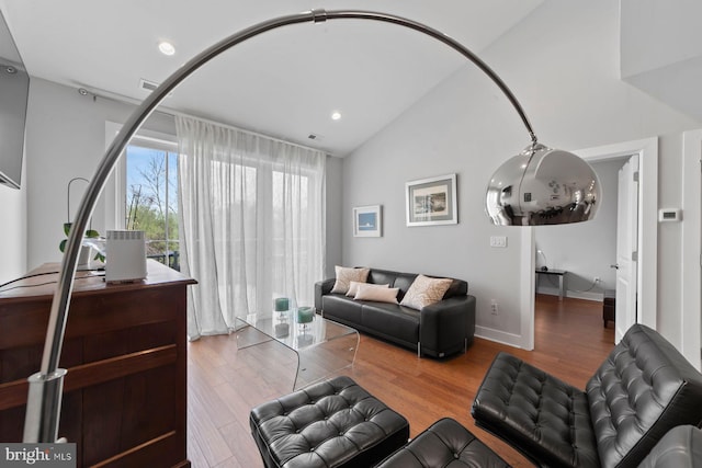 living area with recessed lighting, lofted ceiling, and wood finished floors