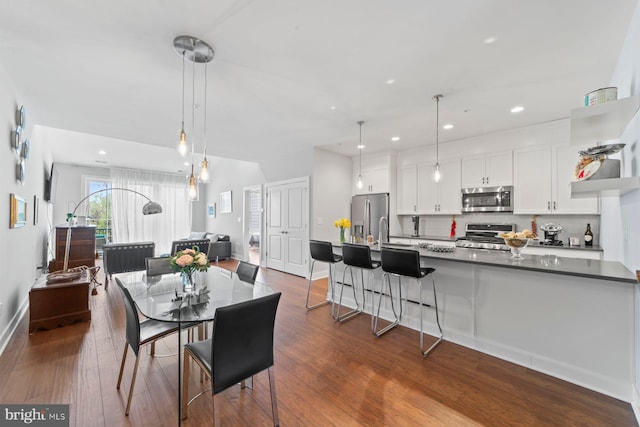 dining area featuring baseboards, dark wood-style floors, and recessed lighting