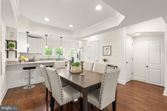 dining room with recessed lighting, a raised ceiling, crown molding, and dark wood-style flooring