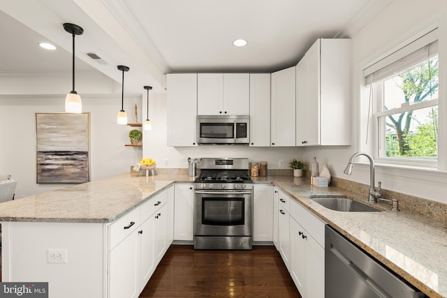 kitchen with visible vents, appliances with stainless steel finishes, a sink, a peninsula, and white cabinetry