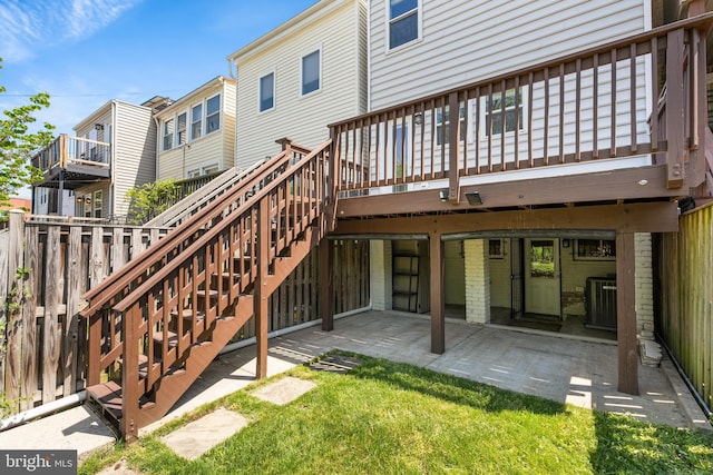 rear view of house featuring fence, a deck, a patio, central air condition unit, and stairway