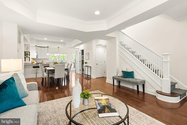 living room featuring stairs, recessed lighting, a raised ceiling, and wood finished floors