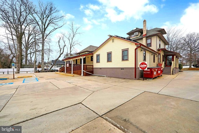 view of home's exterior featuring crawl space and a chimney