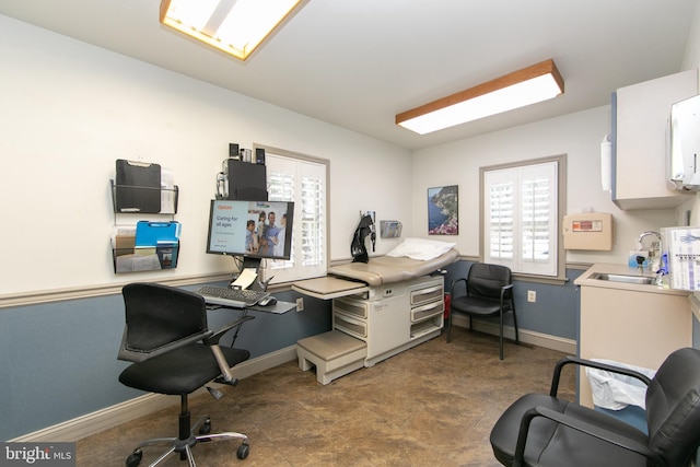 office featuring baseboards and a sink