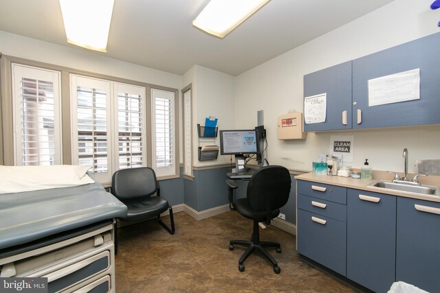 office space featuring baseboards and a sink