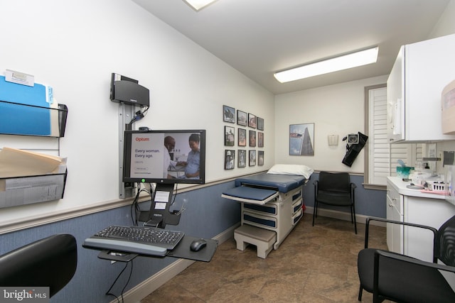 office space with stone finish floor and baseboards