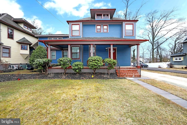 american foursquare style home with a front yard and covered porch
