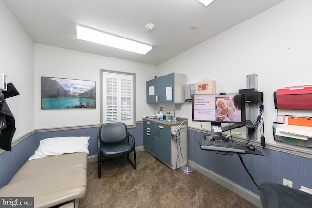 office space with baseboards and a sink