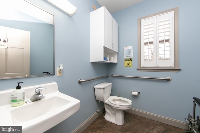 bathroom with baseboards, a sink, and toilet