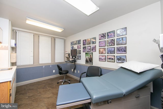 office space with baseboards and a sink