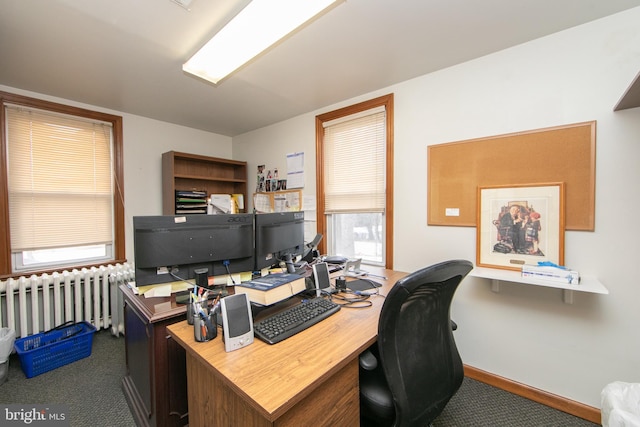 home office featuring dark colored carpet, radiator heating unit, and baseboards