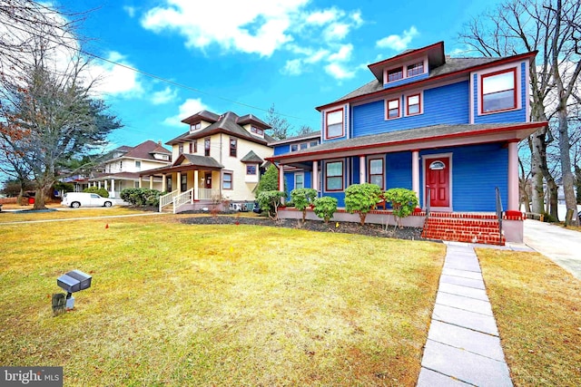 view of front facade with a front lawn, covered porch, and roof with shingles