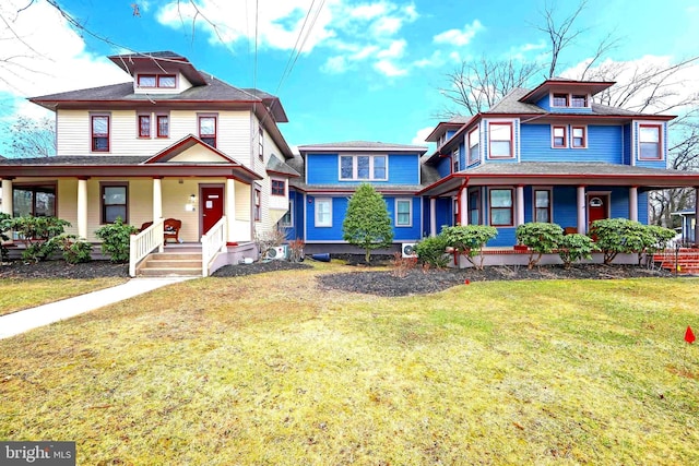 view of front of home featuring roof with shingles, a front yard, and covered porch