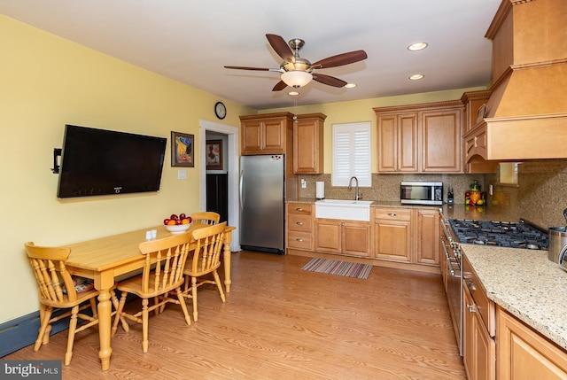 538 Gainsboro Rd, Drexel Hill, PA 19026 - kitchen featuring light wood-style flooring, a ceiling fan, decorative backsplash, stainless steel appliances, and a sink