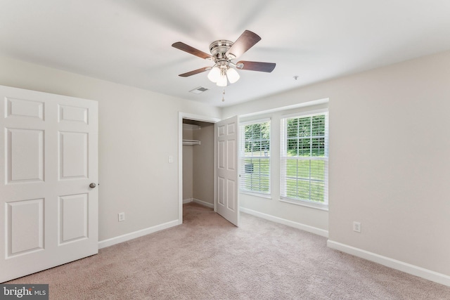 unfurnished bedroom with ceiling fan, visible vents, baseboards, a closet, and carpet