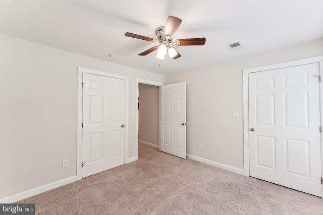 unfurnished bedroom with visible vents, baseboards, carpet floors, and ceiling fan