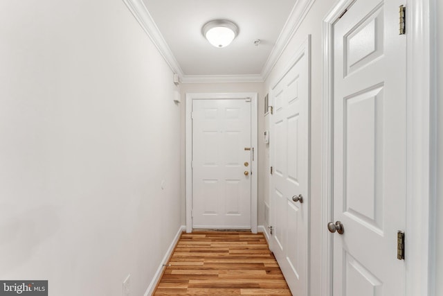 entryway featuring baseboards, ornamental molding, and light wood-style flooring