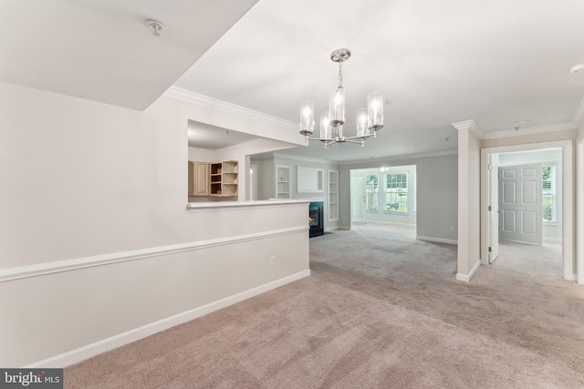 empty room with baseboards, carpet flooring, a chandelier, and ornamental molding