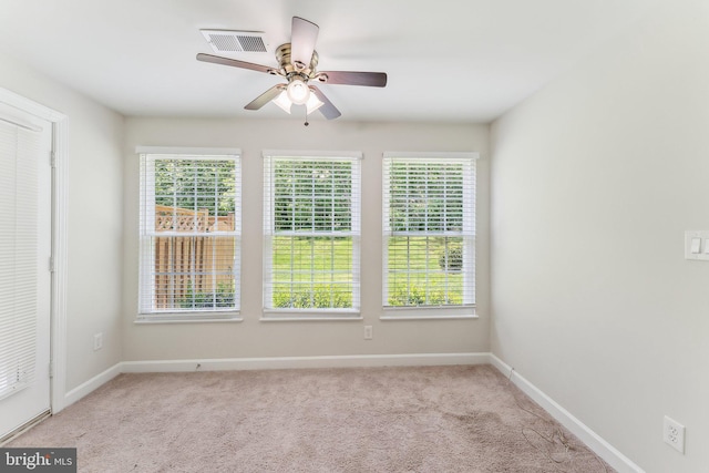 carpeted empty room featuring baseboards, ceiling fan, and visible vents