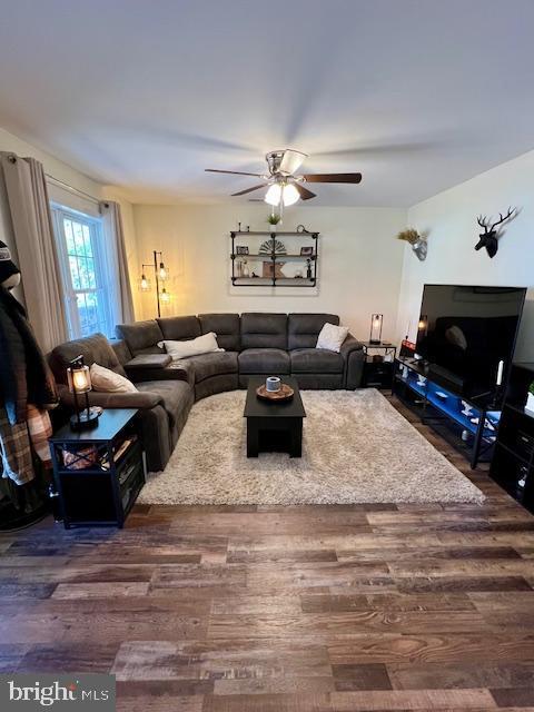 living area featuring dark wood-style flooring and ceiling fan