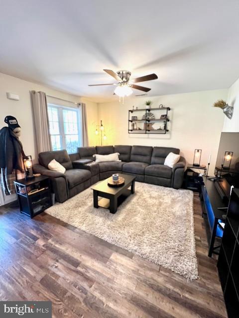 living area with dark wood finished floors and ceiling fan