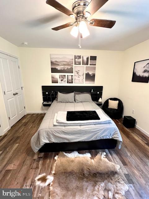 bedroom featuring wood finished floors, baseboards, and ceiling fan