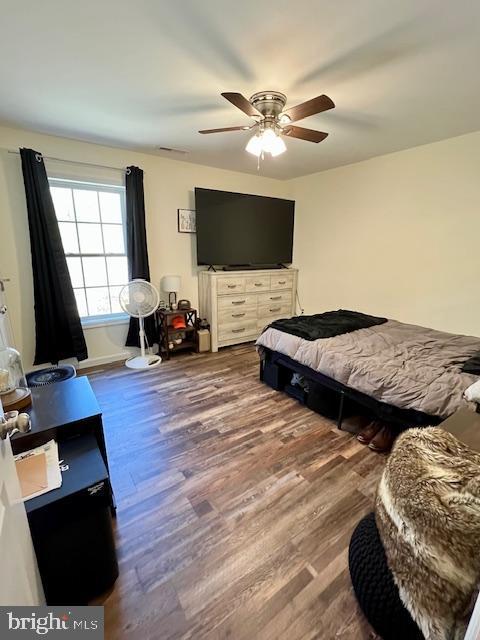 bedroom featuring wood finished floors, ceiling fan, and baseboards