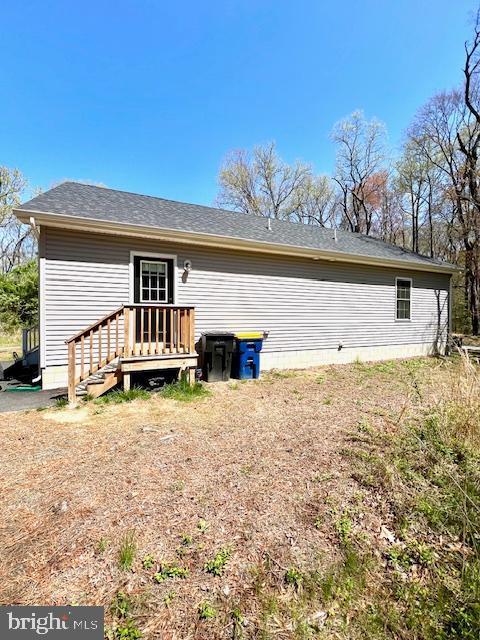 back of property featuring a shingled roof
