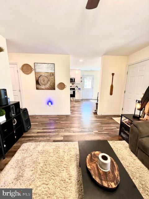 living room featuring wood finished floors and a ceiling fan