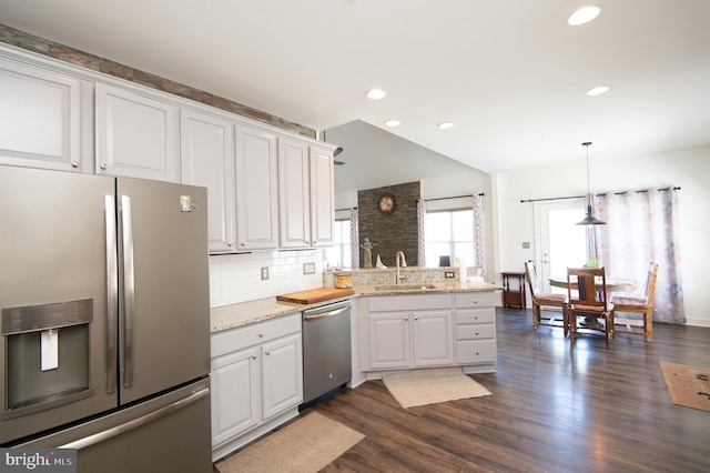 304 Regulator Dr S, Cambridge, MD 21613 - kitchen with a peninsula, dark wood-style floors, a sink, decorative backsplash, and appliances with stainless steel finishes