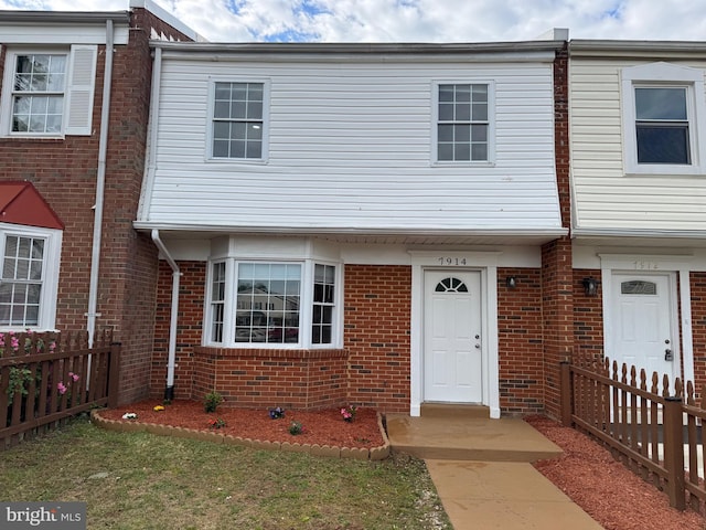 townhome / multi-family property with brick siding and fence