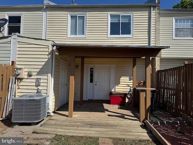back of property featuring fence, a wooden deck, and central AC