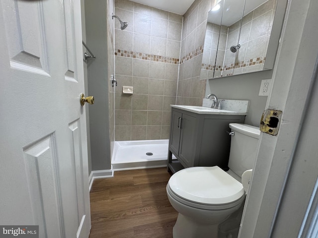 bathroom featuring vanity, a shower stall, toilet, and wood finished floors