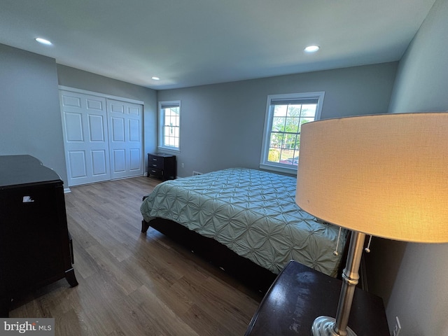 bedroom with recessed lighting, wood finished floors, and a closet