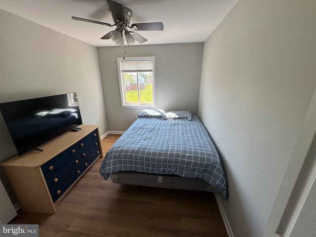 bedroom featuring a ceiling fan, baseboards, and dark wood finished floors