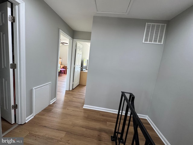 corridor with visible vents, baseboards, and wood finished floors