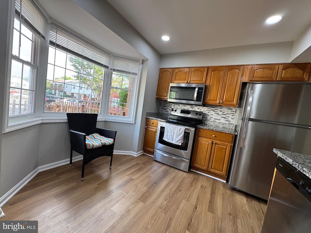kitchen featuring stone countertops, brown cabinets, and stainless steel appliances