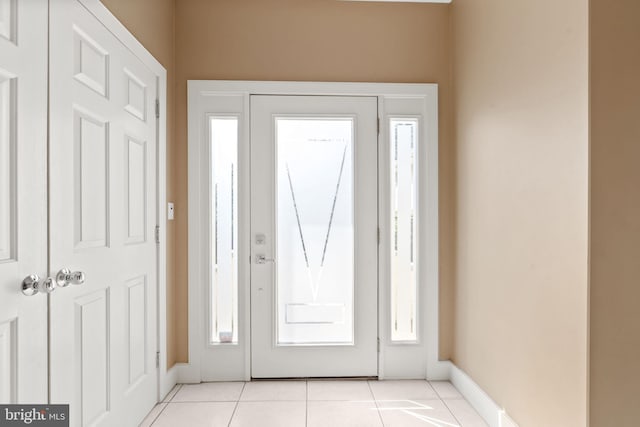 entrance foyer with light tile patterned floors and baseboards