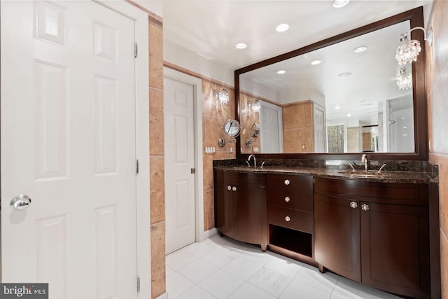 bathroom with a sink, tile patterned floors, double vanity, and recessed lighting