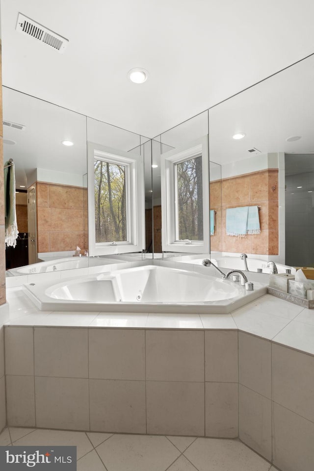 bathroom featuring tile patterned floors, a whirlpool tub, and visible vents