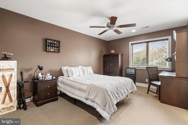 bedroom with visible vents, light colored carpet, baseboards, and a ceiling fan
