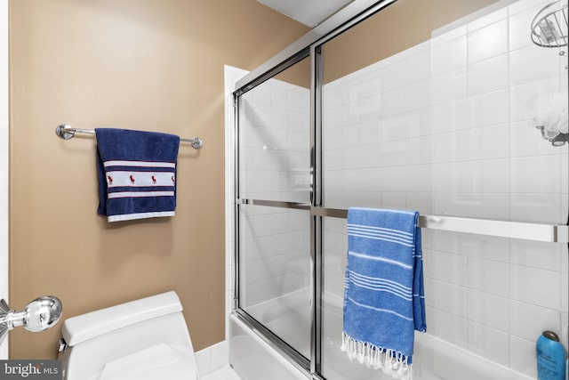 full bathroom with toilet and combined bath / shower with glass door