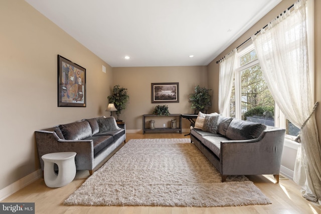 living room featuring baseboards, recessed lighting, and wood finished floors