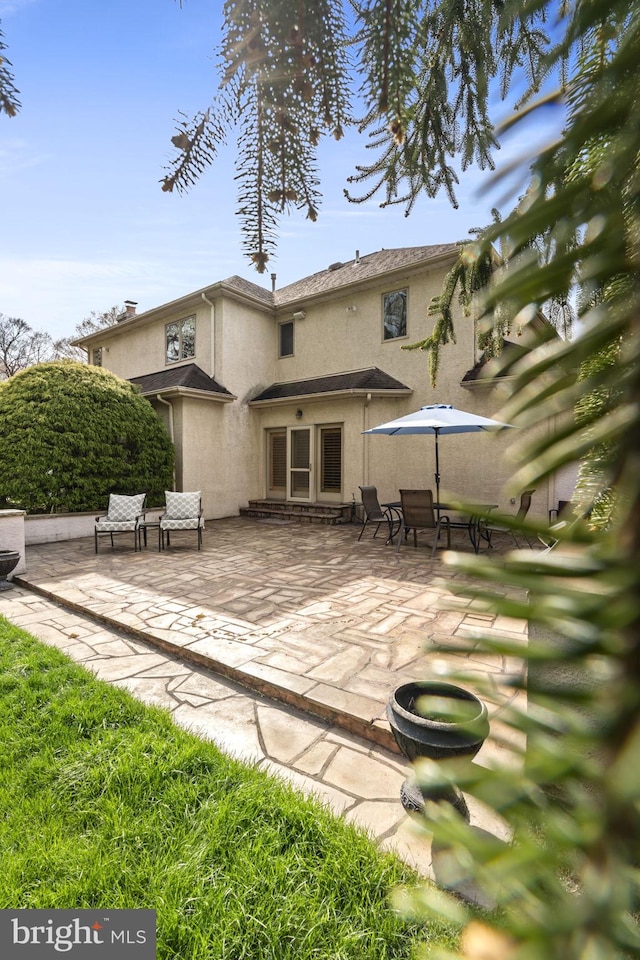 rear view of property featuring a patio area and stucco siding