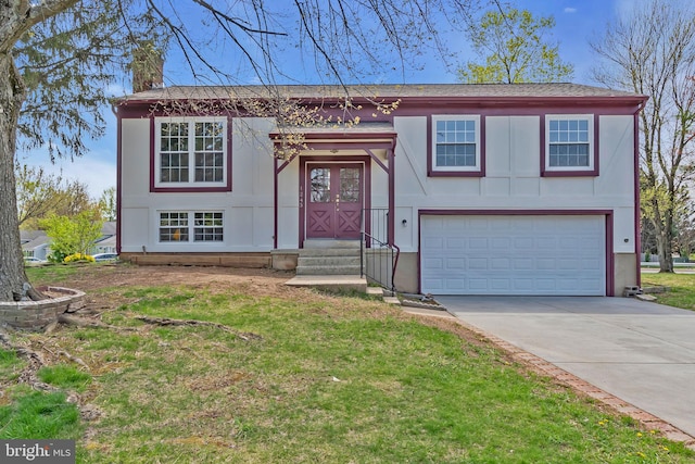 raised ranch with a garage, a chimney, a front yard, and concrete driveway