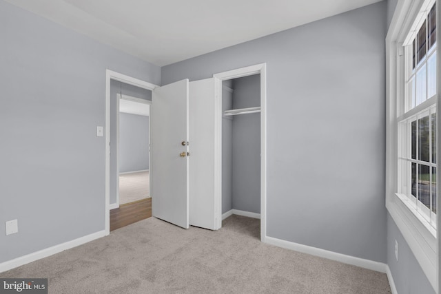 unfurnished bedroom with baseboards, a closet, and carpet