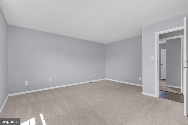 carpeted spare room with baseboards