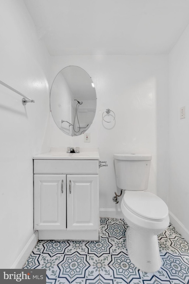bathroom featuring vanity, toilet, and baseboards