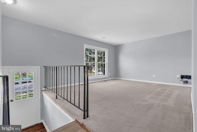 unfurnished room featuring baseboards and carpet