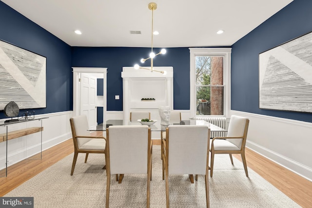 3218 13th St NW, Washington, DC 20010 - dining space with wood finished floors, visible vents, a wainscoted wall, and an inviting chandelier